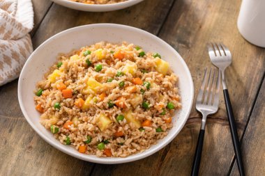 Ananas, havuç ve bezelyeli vejetaryen pilavı, dengeli vegan yemeği fikri.