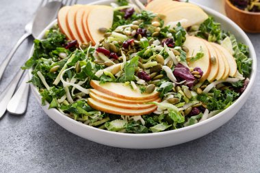 Elma dilimleri, fındıklı ve soslu besleyici lahana salatası.