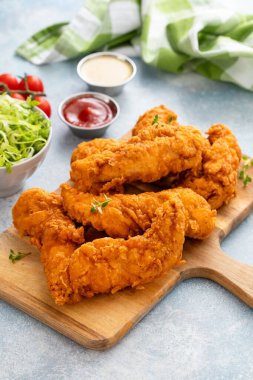 Sos ve salata ile servis edilen servis masasında kızarmış tavuk eti.