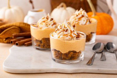 Fincanda balkabağı tatlısı, puding olsun ya da olmasın baharatlı peynirli kek, karamel sosu ve çırpılmış krema.