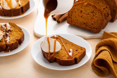 Krem şanti ve karamel şurubuyla kaplı balkabağı ekmeği. Şükran Günü tatlı fikri.