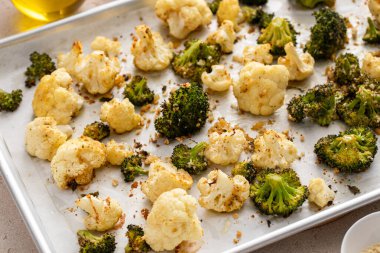 Brokoli ve karnabahar, otlar, baharatlar ve ekmek kırıntılarıyla pişirme çarşafında kızartılır.