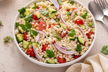 Taze bitki, sebze ve kırmızı soğanlı inci kuskus salatası.