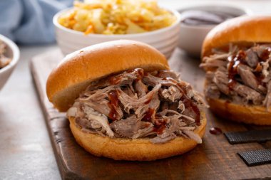 Brioche çörekleri üzerinde domuz sandviçi, barbekü sosu ve sotelenmiş lahana.