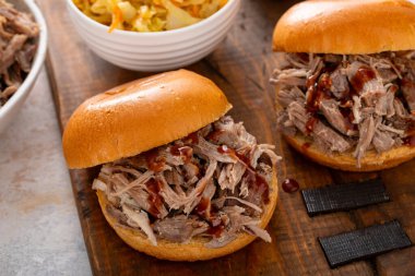 Brioche çörekleri üzerinde domuz sandviçi, barbekü sosu ve sotelenmiş lahana.