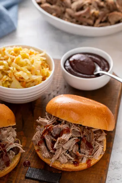 Brioche çörekleri üzerinde domuz sandviçi, barbekü sosu ve sotelenmiş lahana.