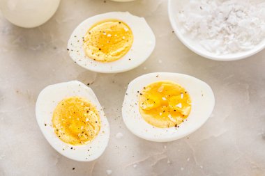 Kaynamış yumurta, tuz ve karabiber ile ikiye bölünmüş.