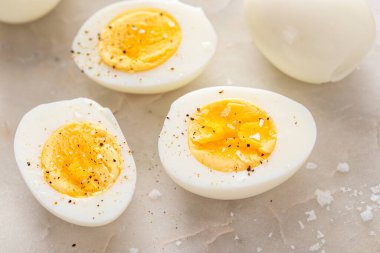 Kaynamış yumurta, tuz ve karabiber ile ikiye bölünmüş.