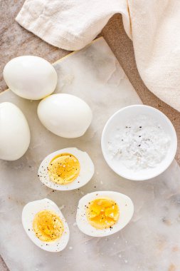 Kaynamış yumurta, tuz ve karabiber ile ikiye bölünmüş.