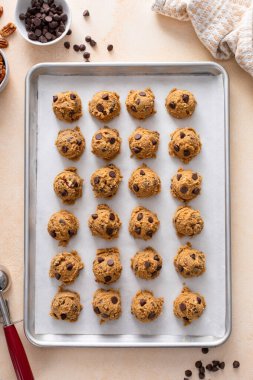 Cevizli çikolata parçacıklı kurabiyeler, kurabiye hamuru bir tepside kepçelenmiş.