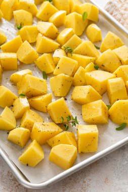 Çiğ patates, sarımsak, bitki ve baharatla kızartılmaya hazır bir tavada dilimlenmiş.