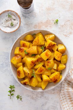 Sarımsak, otlar ve baharatlarla pişirilmiş servis kâsesinde fırında patates.