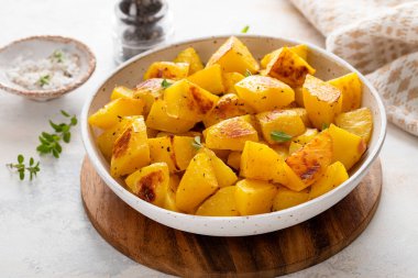 Sarımsak, otlar ve baharatlarla pişirilmiş servis kâsesinde fırında patates.