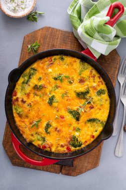 Brokoli, pastırma ve peynirli frittata dökme demir tavada pişmiş.