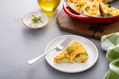 Brokoli, pastırma ve peynirli frittata dökme demir tavada pişirilmiş ve dilimlenmiş.