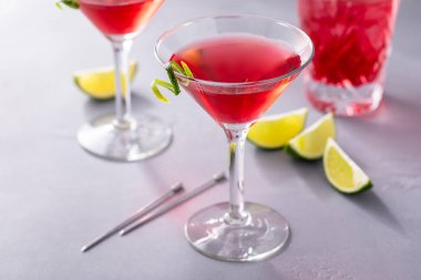 Geleneksel bardaklarda limon bükümlü Cosmopolitan kokteyli.