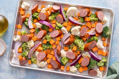 Sebzeler ve sosis tabakası akşam yemeği karnabahar, brokoli ve kırmızı soğanla kızartılmaya hazır.