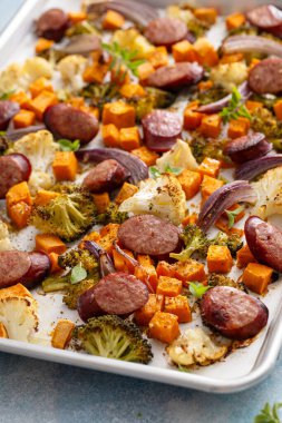 Sebzeler ve sosis çarşafı yemek fırını karnabahar, brokoli ve kırmızı soğanla kızartılmış.