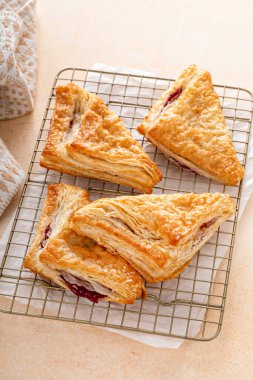 Fırında pişmiş ve yemeye hazır kiraz ya da çilek reçelli puf börekleri.