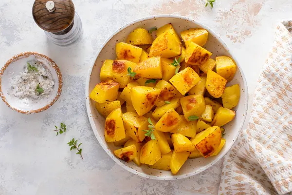 Sarımsak, otlar ve baharatlarla pişirilmiş servis kâsesinde fırında patates.