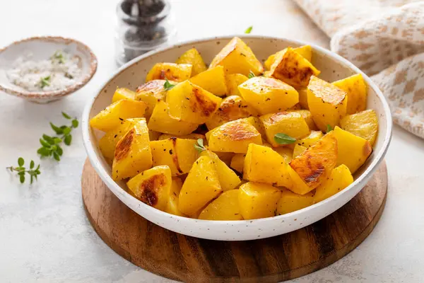 Sarımsak, otlar ve baharatlarla pişirilmiş servis kâsesinde fırında patates.