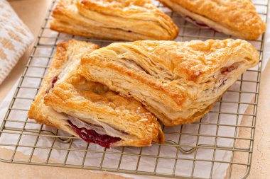 Fırında pişmiş ve yemeye hazır kiraz ya da çilek reçelli puf börekleri.