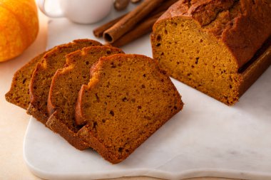 Pumpkin ekmeği servis panosunda taze dilimlenmiş, Şükran Günü tatlı fikri.