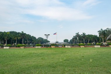 Rizal Park, Manila, Filipinler 2 Temmuz 2014: Filipin bayrağı Manila, Filipinler 'deki Rizal Park' ın arka planında