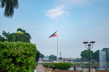 Rizal Park, Manila, Filipinler 2 Temmuz 2014: Filipin bayrağı Manila, Filipinler 'deki Rizal Park' ın arka planında