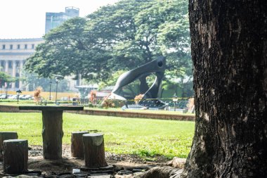 Rizal Park, Manila, Filipinler 2 Temmuz 2014: Taft Caddesi, Manila, Filipinler yakınlarındaki Rizal Park 'taki bir ağacın altında masa ve sandalyeler