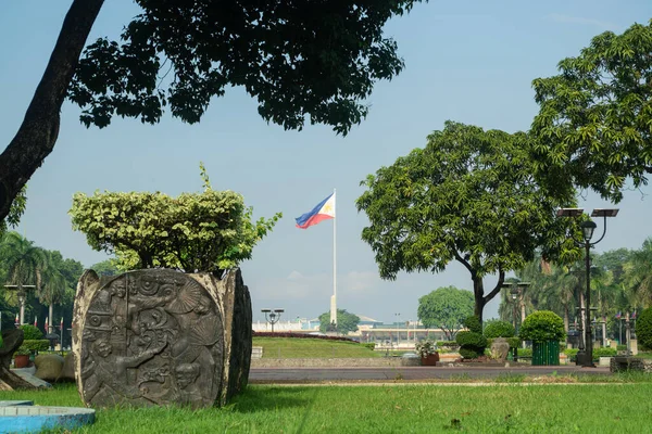 Rizal Park, Manila, Filipinler 2 Temmuz 2014: Filipin Bayrağı Manila, Filipinler 'deki Rizal Park' ta çimenler ve ağaçlar tarafından çerçevelendi