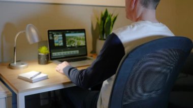 Adamın biri ev ofisinin bilgisayarında video düzenliyor..  