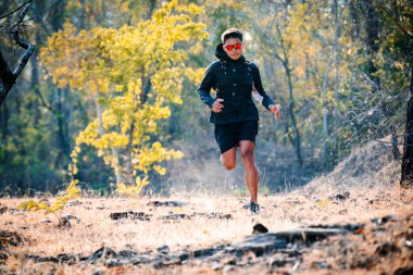 Man trail running in forest cross country running along trail