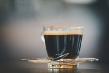 Cup of black coffee on wooden table in coffee shop. Copy space. Indoor.