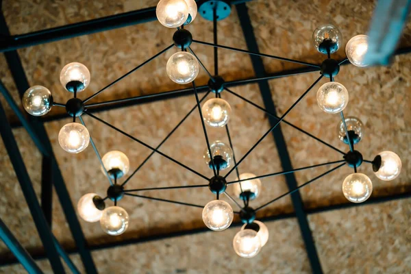 Antique electronic decorative lamp in factory in restaurant or cafe: Close up of a hanging, orange lightbulbs