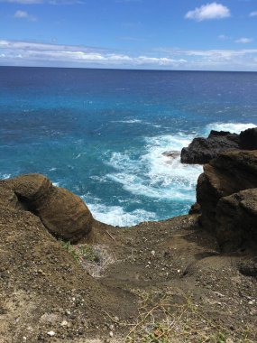 Honolulu Sahili dağları, büyük kayalar, mavi sular ve yüksek dalgalar.