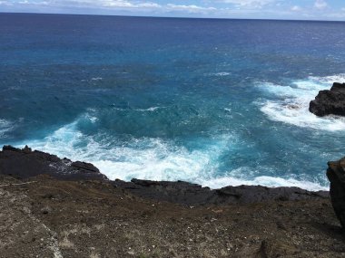 Honolulu Sahili dağları, büyük kayalar, mavi sular ve yüksek dalgalar.