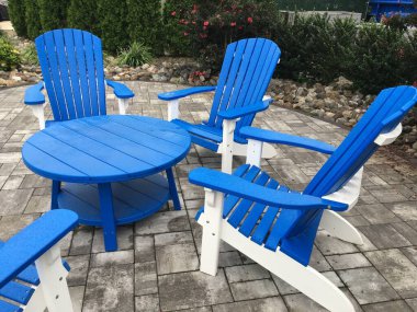 Mavi ve beyaz sandalyeli terasta sandalye ve masa dikey görüntüsü.