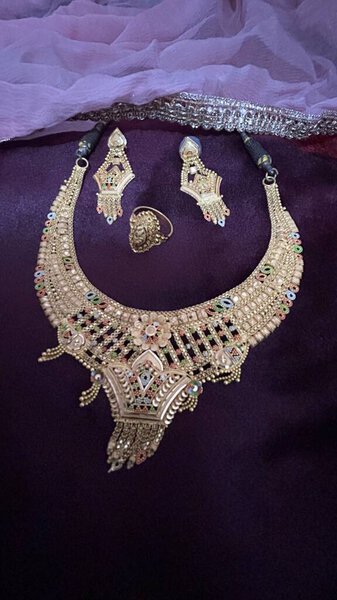 beautiful wedding rings, golden necklace, golden earrings on the velvet purple background, express love with golden jewelry. Perfect for wedding, engagement and anniversary. Indian Golden Jewlery gift ideas for women.