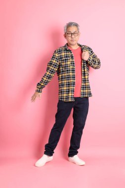 Pembe arka planda duran yaşlı Asyalı adamın boyu....