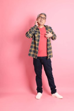 Pembe arka planda duran yaşlı Asyalı adamın boyu....