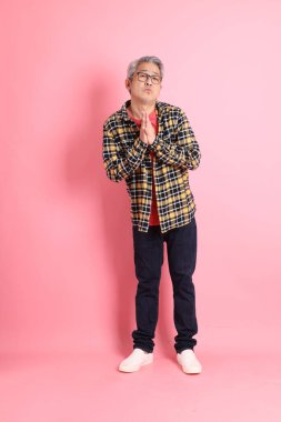 Pembe arka planda duran yaşlı Asyalı adamın boyu....