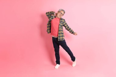 Pembe arka planda duran yaşlı Asyalı adamın boyu....