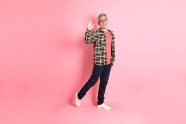 Pembe arka planda duran yaşlı Asyalı adamın boyu....