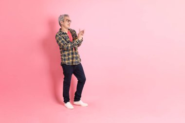 Pembe arka planda duran yaşlı Asyalı adamın boyu....