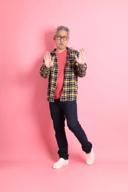 Pembe arka planda duran yaşlı Asyalı adamın boyu....