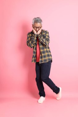 Pembe arka planda duran yaşlı Asyalı adamın boyu....