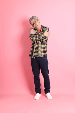 Pembe arka planda duran yaşlı Asyalı adamın boyu....