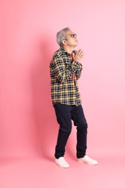 Pembe arka planda duran yaşlı Asyalı adamın boyu....