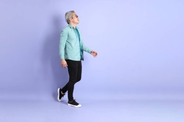 Mor arka planda duran yaşlı Asyalı adamın boyu....